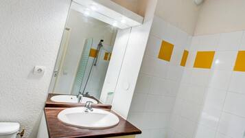 Un baño con dos lavamanos, un espejo y una ducha.