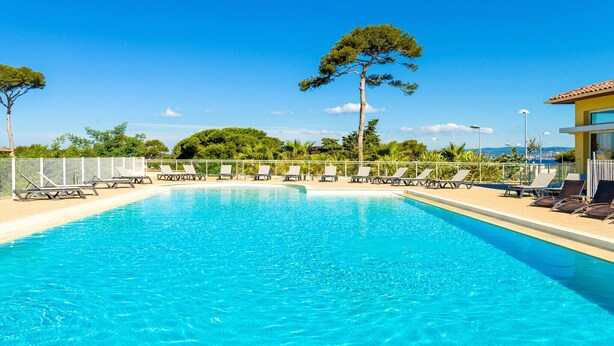 Ein Schwimmbecken mit Liegestühlen und Blick auf die Landschaft.