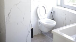 A bathroom with a toilet, a bathtub, and a window. - Alv Rent Room (Vlorë)