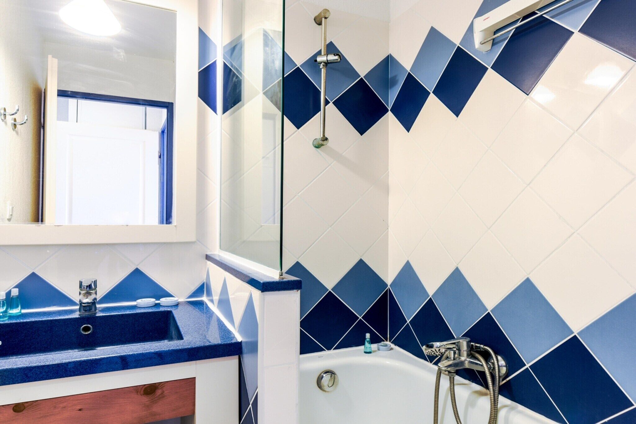 Un bagno con lavandino, specchio e doccia.