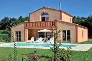 A two-story house with a swimming pool, outdoor seating, and a garden.
