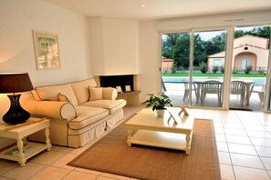 A living room with a sofa, a coffee table, a lamp, and a fireplace.