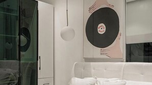 Ein modernes Schlafzimmer mit Bett, Kleiderschrank und Wandbild.