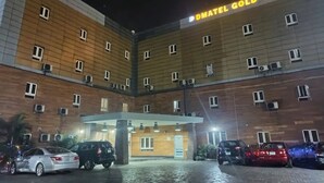 Ein mehrstöckiges Hotel mit einem Schild, auf dem 'DMATEL GOLD HOTEL' steht.