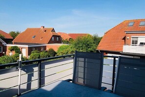 A residential area with houses, a gated entrance, and a clear sky. - Holiday apartment in Greetsiel with Wi-Fi (Greetsiel)