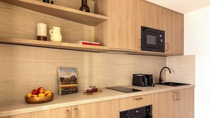 Una cocina moderna con armarios de madera, microondas, lavaplatos y fregadero.