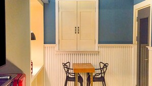 A small room with a white cabinet, a table with two chairs, and a door. - 747 Motel (Gimcheon)