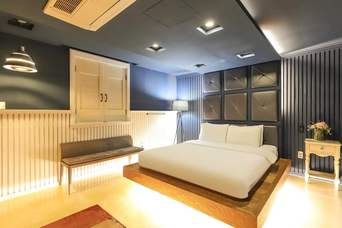 A modern bedroom with a bed, bedside table, lamp, and radiator.