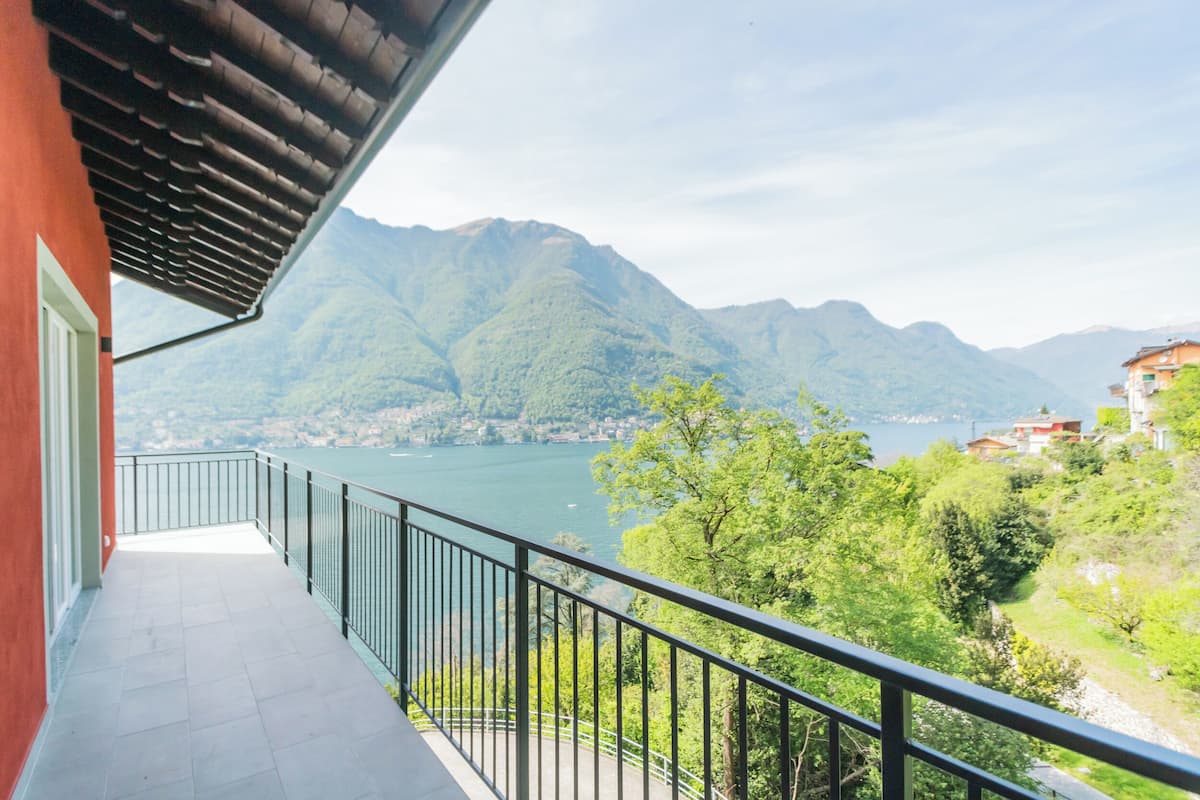 A balcony with a view of a lake and mountains.