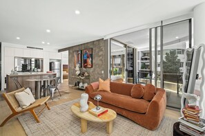 Ein modernes Wohnzimmer mit einer Couch, einem Couchtisch und einem Essbereich mit Stühlen und Tisch.