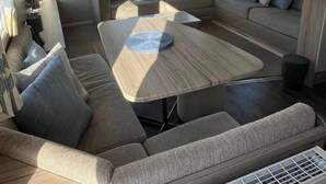 Un espacio habitable pequeño con un sofá, una mesita y un diván.