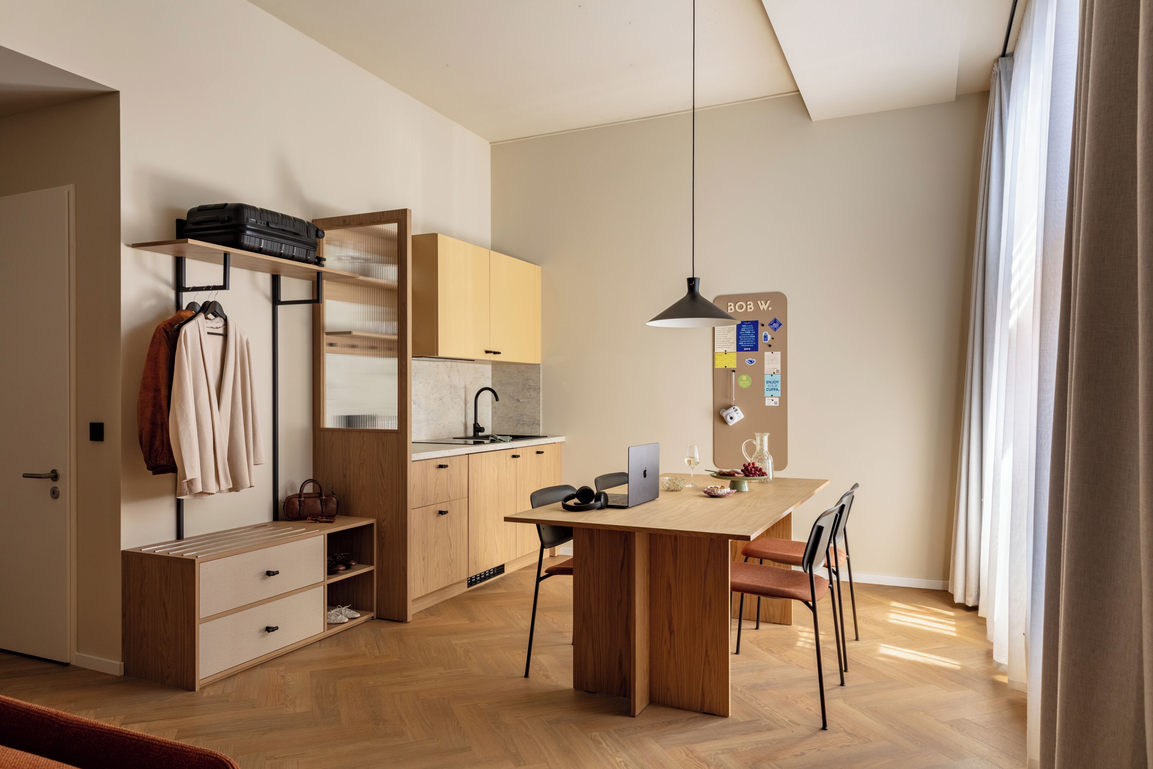 Una cocina moderna con una mesa de madera, sillas e iluminación colgante.