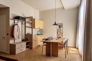 A modern kitchen with a wooden table, chairs, and a hanging pendant light. - Bob W Dortmund Stadtmitte (Dortmund)