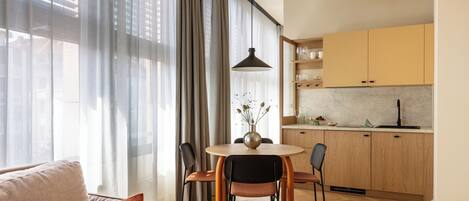 Une cuisine moderne avec des meubles en bois et un coin repas comprenant une table ronde et des chaises.