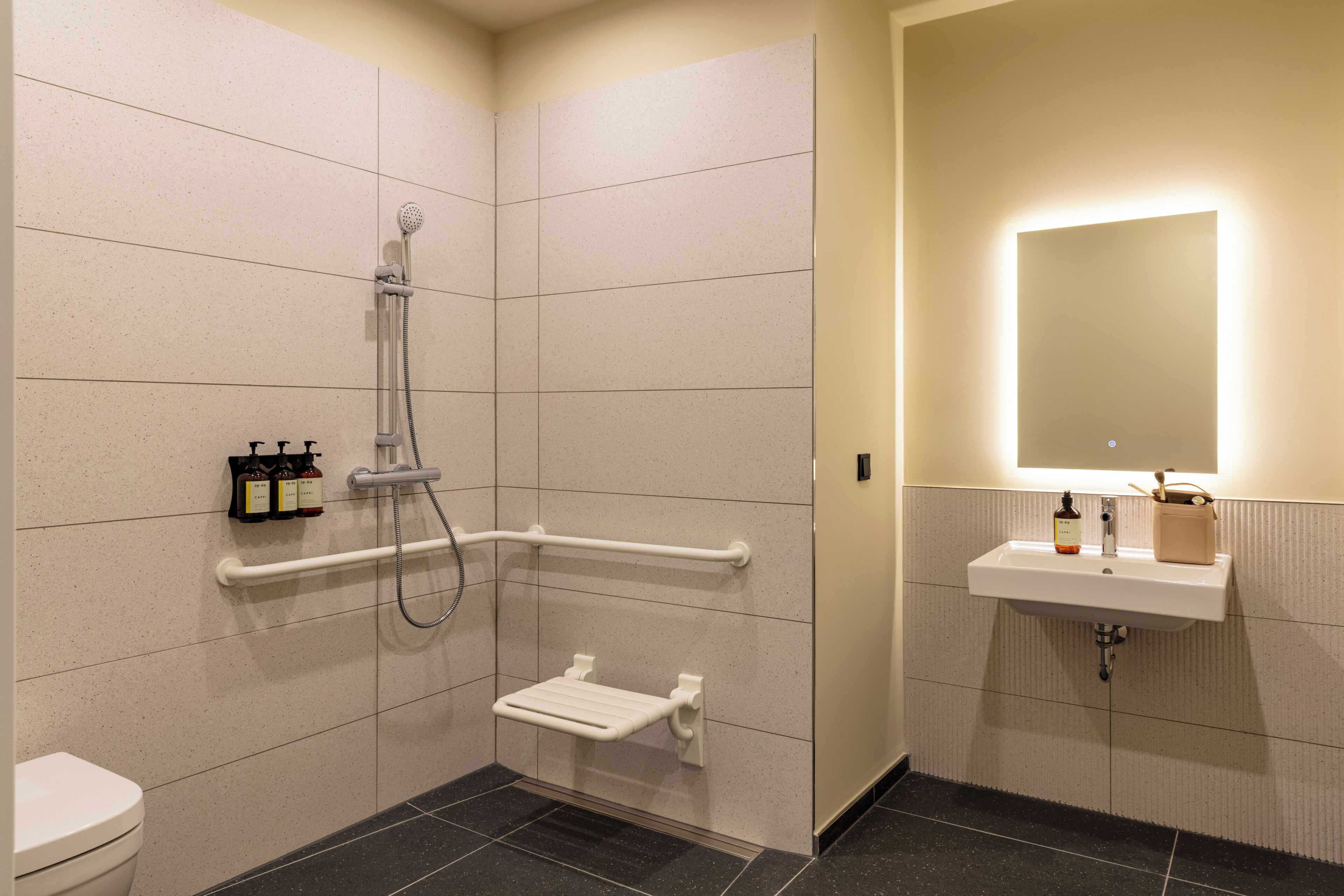 Een badkamer met een douche, toilet en wastafel.
