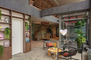 A spacious indoor area with a staircase, seating area, and a large window. - Bob W Dortmund Stadtmitte (Dortmund)