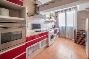 Eine Küche mit Backofen, Waschmaschine und Spüle.