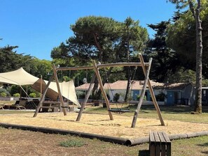 Ein Spielplatz mit Schaukeln und einem Picknickbereich.