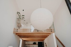 A staircase with wooden steps and a white spherical light fixture.