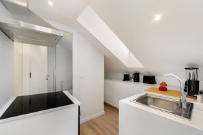 Eine moderne Küche mit einem schwarzen Herd, einer Edelstahl-Spüle und einer Holz Arbeitsplatte.
