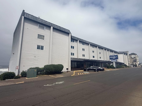A multi-story hotel with a modern design, featuring a prominent sign for the Newport Oceanfront Inn.. Newport Oceanfront Inn