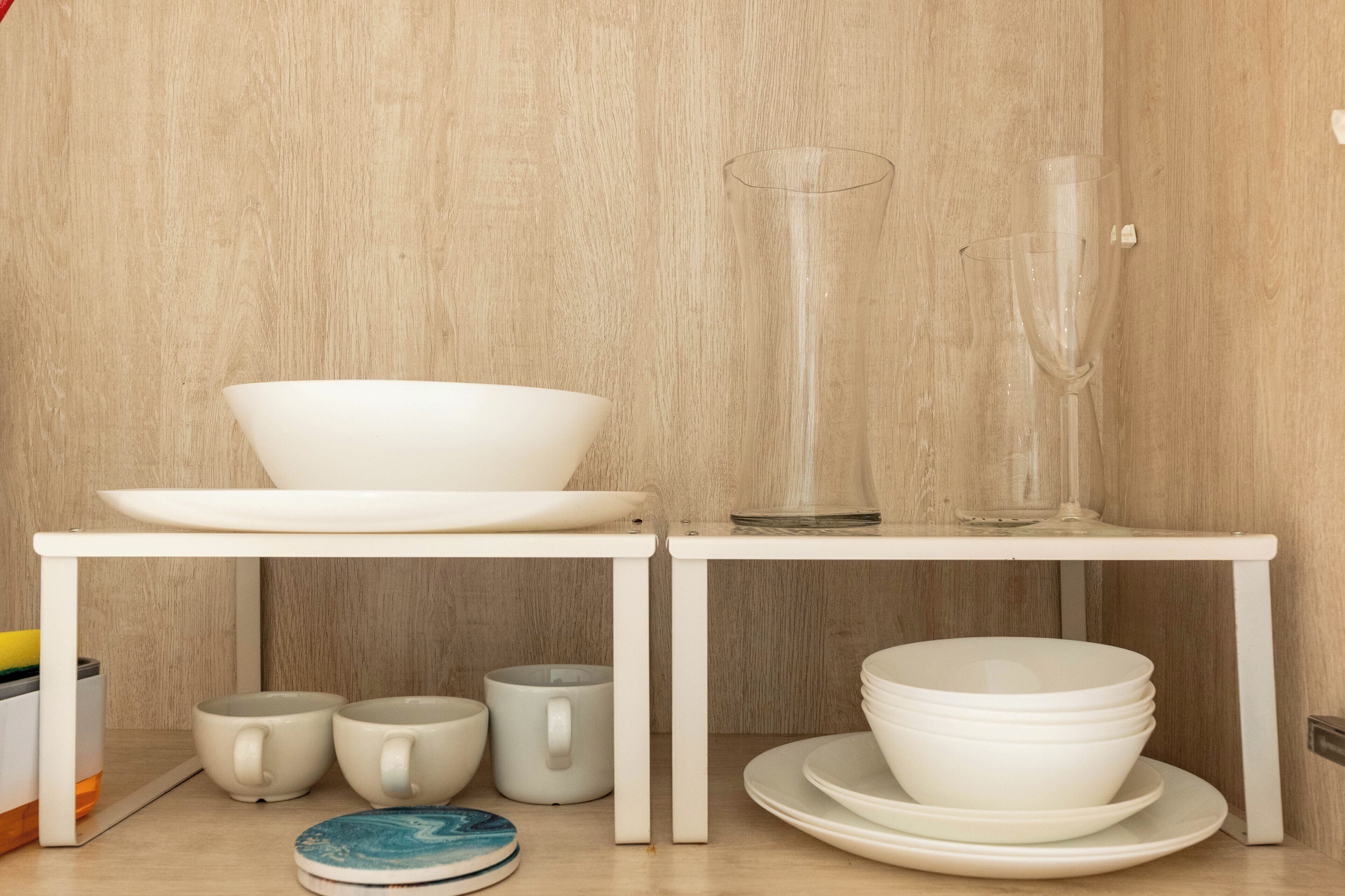A white table with a bowl, a glass, and stacked plates.