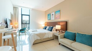A modern hotel room with a bed, a sofa, a desk, and a chair. - Elegant Palm Studio with Sea View & Pool (Dubai)
