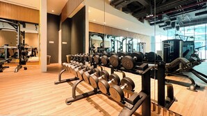 A gym with weightlifting equipment, mirrors, and a wooden floor. - Elegant Palm Studio with Sea View & Pool (Dubai)