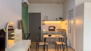 Una cocina compacta con comedor, horno empotrado y una pequeña encimera.