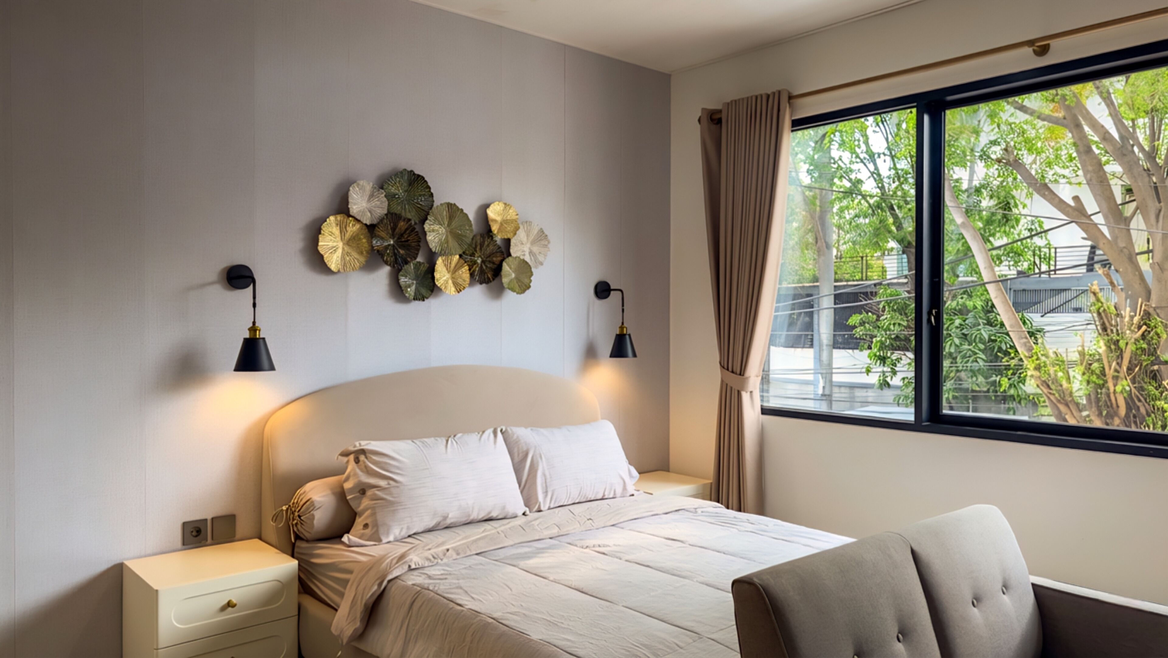 Un dormitorio con cama, mesitas de noche, lámparas de pared y ventana con vistas a zonas verdes.
