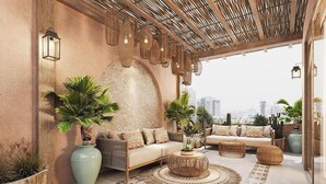 A modern lounge with a sofa, round wicker coffee table, and potted plants.