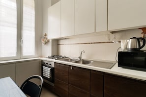 A kitchen with white cabinets, a stainless steel sink, a microwave, and a stove. - Cozy 45m2 apartment, ideal for 4 people, located on the first floor of a building without a lift (steps to access).The accommodation is located in a strategic area, a stone's throw from the M3/M5 Zara stop and the stops of numerous surface transport ve (Milan)