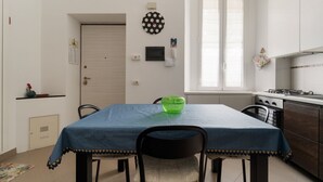 Pieni, käytännöllinen keittiö, jossa on ruokapöytä, tuolit ja ikkuna.
