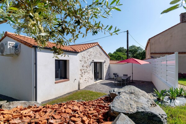 A building with a tiled roof, a white exterior, and a red umbrella.