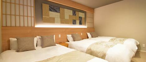 A hotel room with two beds, a wooden headboard, a wall-mounted mirror, and a recessed ceiling light.