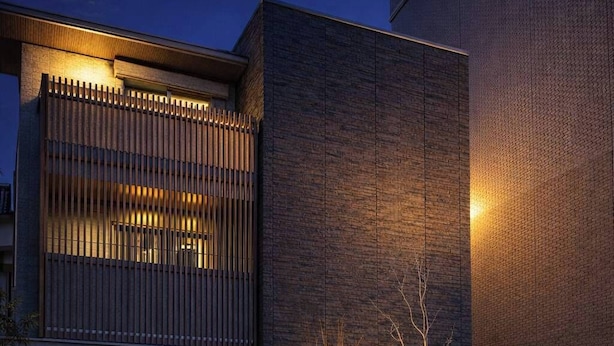 A modern building with a large entrance, a sloped roof, and a well-lit facade. - Kurashiki Station Hotel Wakana (Kurashiki-shi)