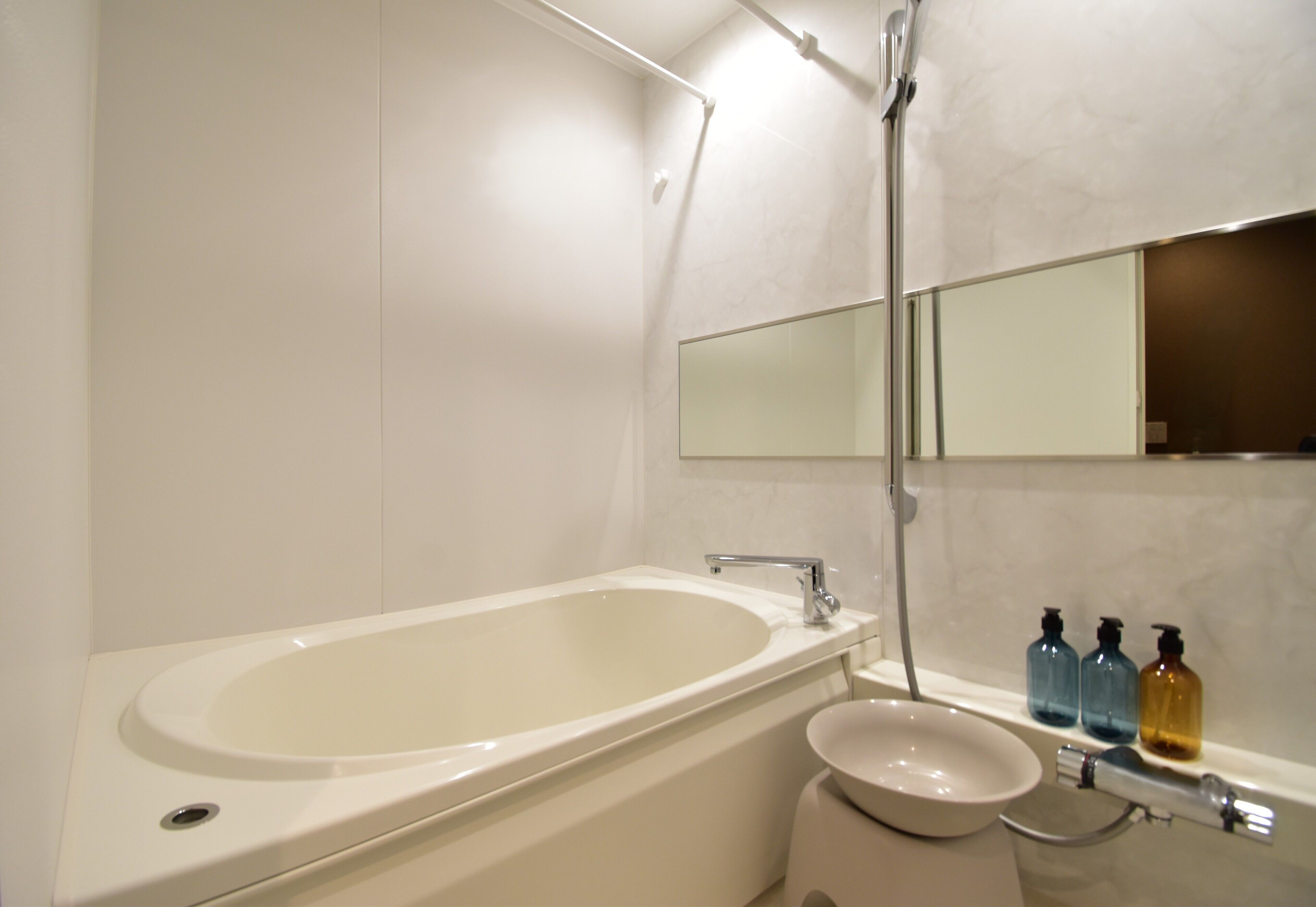A modern bathroom with a bathtub, a sink, and a mirror.