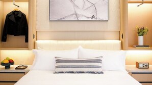 A hotel room with a bed, a nightstand with a radio, a fruit bowl, and a painting on the wall. - The Observatory - A Viceroy Resort (Ketchum)