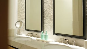 A bathroom with two sinks, a mirror, and toiletries. - The Observatory - A Viceroy Resort (Ketchum)