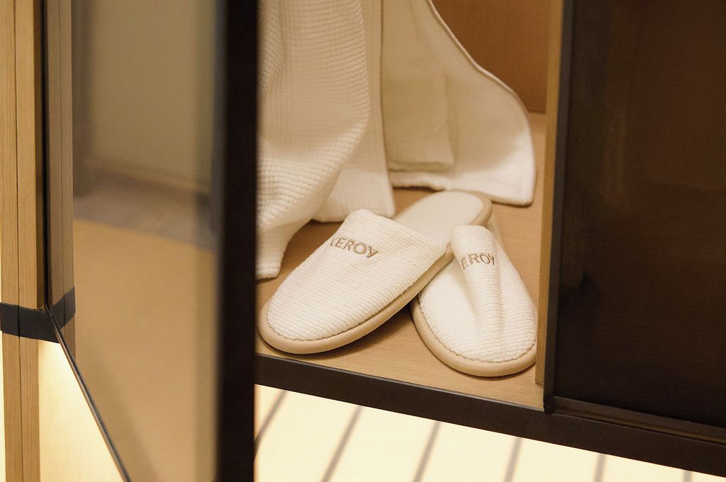 Un par de zapatillas blancas con la marca 'EROY' dentro de una vitrina de cristal.
