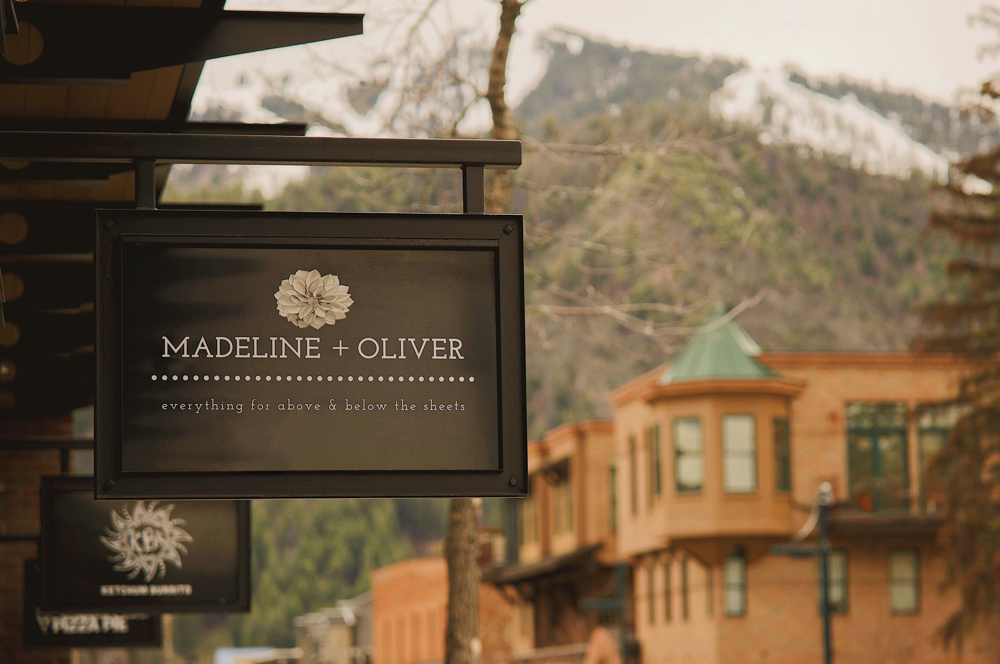 A sign with the name 'Madeline + Oliver' and a floral design, indicating a hotel or establishment.