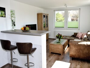 Eine moderne Küche mit Barbereich, einer Couch und einem Couchtisch.