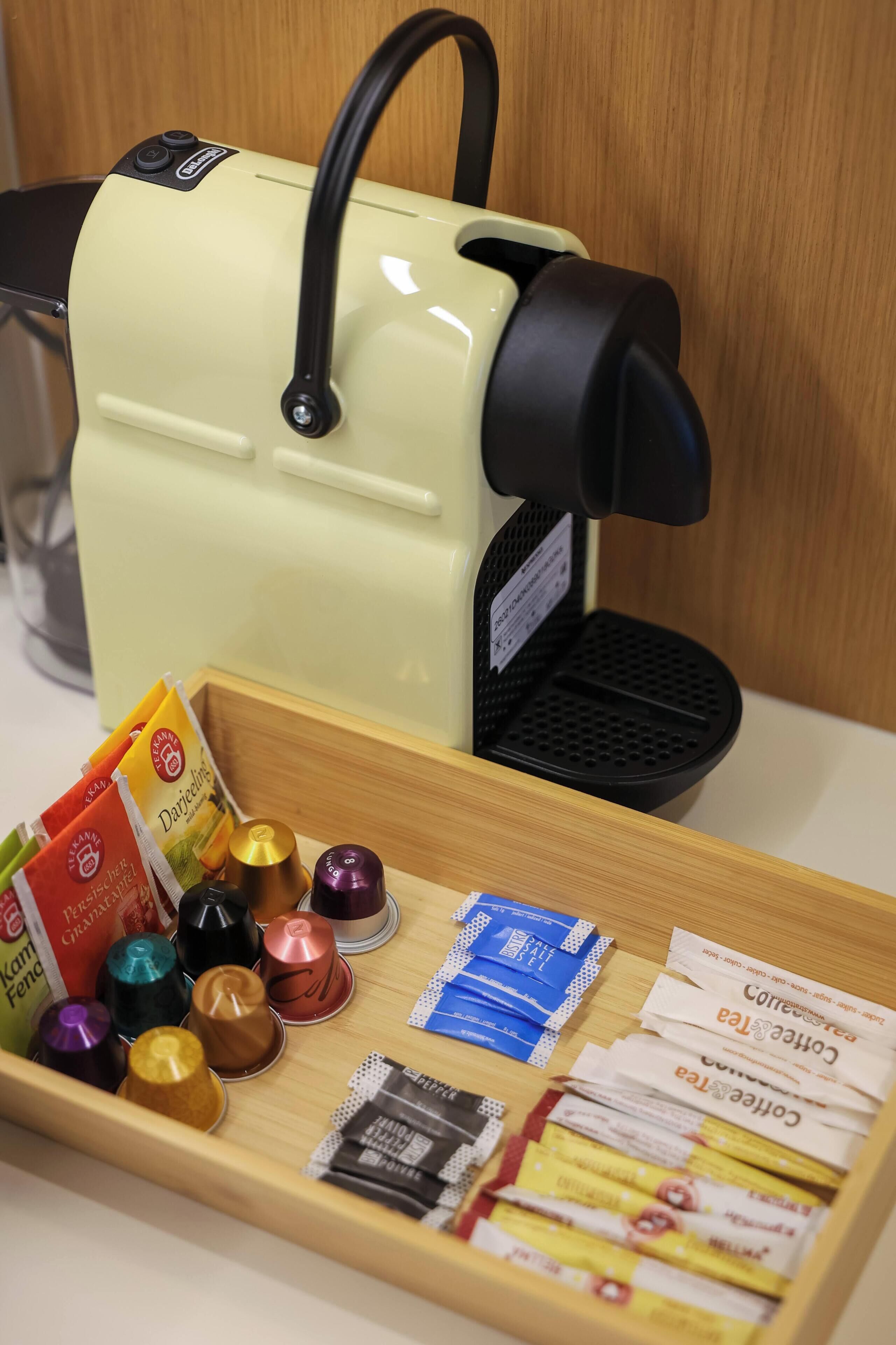 A coffee machine with a tray of coffee pods and capsules.