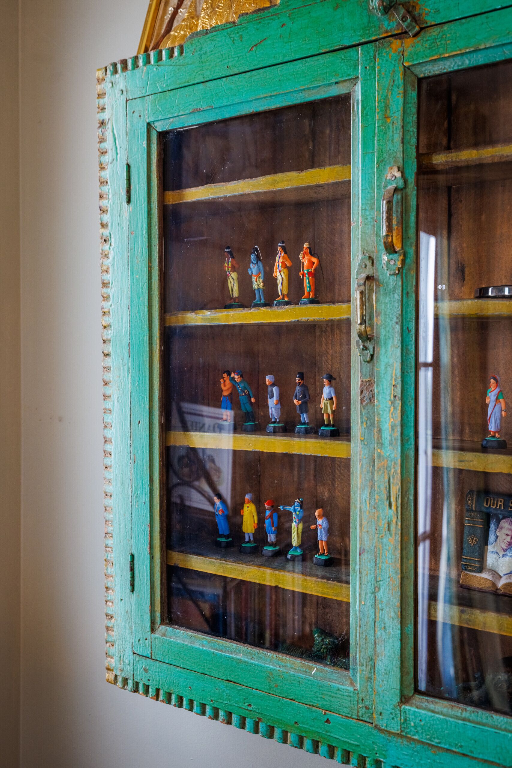 Eine grüne Vitrine mit kleinen Figuren.