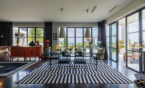 Ein geräumiges Wohnzimmer mit großem Fenster, einem Essbereich und einer Couch.
