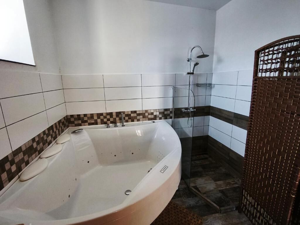 A bathroom with a bathtub, a shower, and a wicker basket.