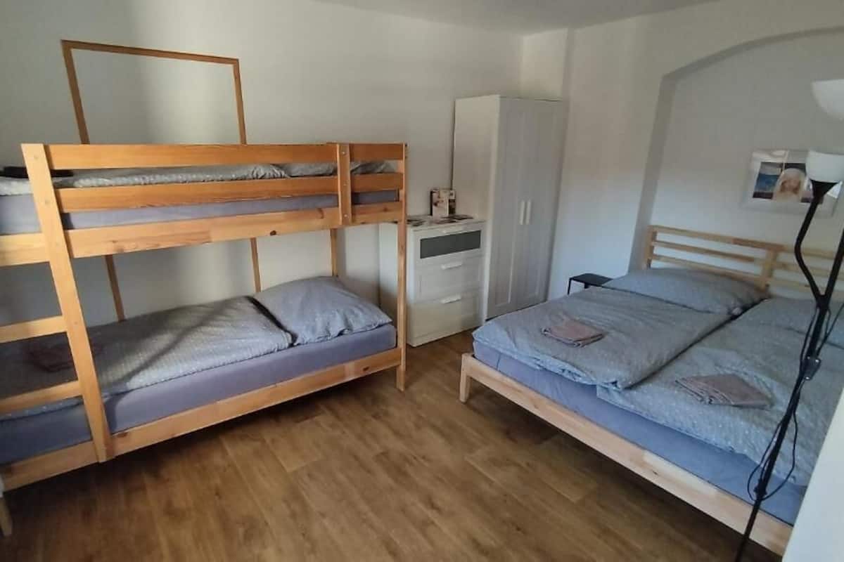A room with bunk beds, a wardrobe, and a desk.