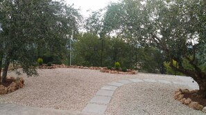 A landscaped garden with gravel paths, olive trees, and a stone border. - THE HOUSE ON THE LAKE - App. WISTERIA - MAIELLA PARK (Abruzzo)