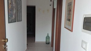 A hallway with a radiator, a door, and a green bottle on the floor. - THE HOUSE ON THE LAKE - App. WISTERIA - MAIELLA PARK (Abruzzo)