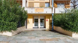 A hotel entrance with a yellow facade, double doors, and a sign indicating 'Hotel & Residence.' - Bright apartment for 4 persons with a mountain view (Grasse)